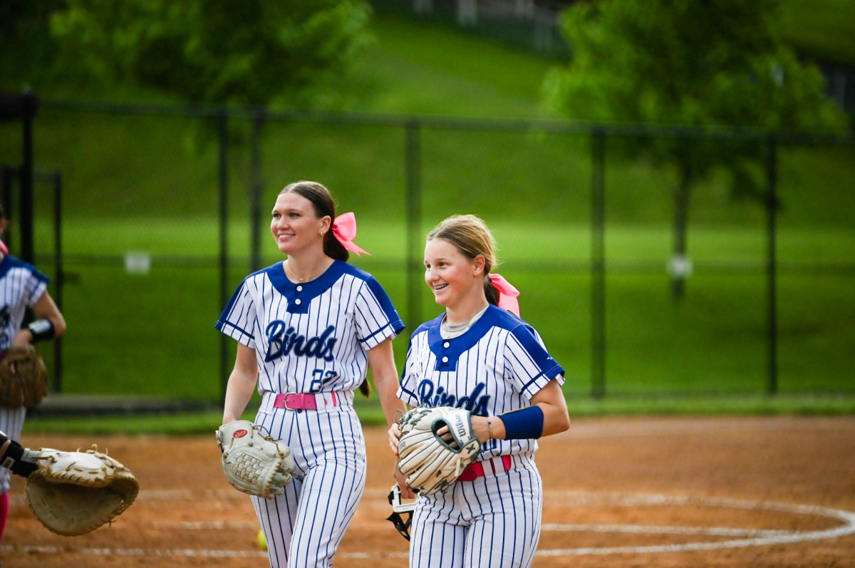 Julia Luhn (12) and Alli Meyers (10) jog off the field with smiles after a clean inning. "We are more than just teammates, we are a family built on dirt," Luhn said. 